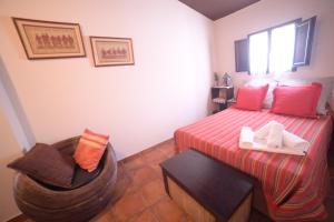 アルカラ・デル・フカルにあるCasa Rural La Rocaのベッドと椅子付きのホテルルーム