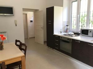 a kitchen with a stove and a sink and a table at La Casa dell'Emigrante in Gaeta