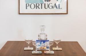 リスボンにあるUnique and Stylish Flat in Historic Lisbonのウォッカのボトル1本(眼鏡付きテーブルに座る)