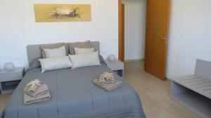 1 dormitorio con 1 cama con toallas en Casa Nettuno, en Granelli