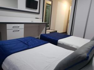 a hotel room with two beds and a tv at Alican 2 in İzmir
