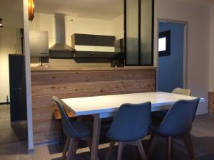 a dining room with a table and blue chairs at Résidence du parc in Briançon