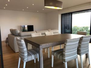 - une salle à manger avec une table, des chaises et un canapé dans l'établissement Astro Vista Madeira Apartments, à Funchal