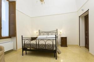 una camera da letto con un letto nero in una stanza bianca di Villa Degli Eroi a Nardò