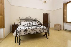 un letto nero in una stanza con una sedia di Villa Degli Eroi a Nardò