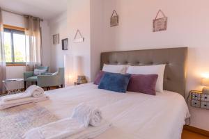 um quarto com uma grande cama branca com toalhas em Sunset Relaxing Apt with terrace, parking & bikes em Porto
