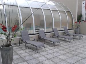 un groupe de chaises devant un bâtiment dans l'établissement Land Plaza Hotel, à Bahía Blanca