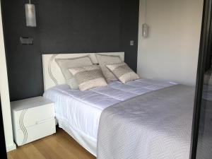 - une chambre avec un lit blanc et des oreillers dans l'établissement Astro Vista Madeira Apartments, à Funchal
