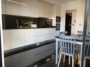 eine Küche mit weißen Schränken und eine Bar mit einem Stuhl in der Unterkunft Astro Vista Madeira Apartments in Funchal
