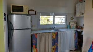 a kitchen with a refrigerator and a microwave at Estancia de Campo in Estancia Vieja +17 photos