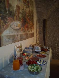 una mesa con platos de comida y fruta. en Agriturismo Valentina Cubi, en Fumane