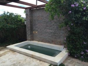 a swimming pool in front of a brick wall at The Cowshed in McGregor