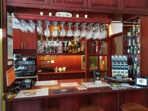a bar with glasses hanging over a counter at Centrum Panzió in Szentendre