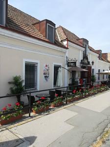 a building with tables and flowers on a street at Centrum Panzió in Szentendre