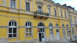 ルセにあるHostel Ruschukの通りに面した黄色の建物