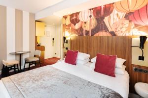 リヨンにあるメルキュール リヨン サントル プラザ レピュブリックの大きなベッド(赤い枕付)が備わる客室です。