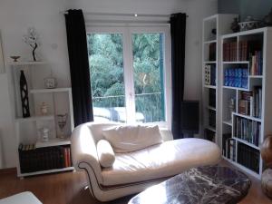 - un salon avec un canapé blanc devant une fenêtre dans l'établissement Les Floralies, à Pau