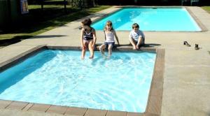 a group of children sitting in a swimming pool at High Country Motor Inn Bright in Bright