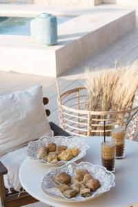 a table with two plates of pastries on it at Niovi Boutique Apartments in Afitos