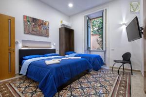 a bedroom with two blue beds and a chair at B&B D'AMICO in Cava deʼ Tirreni