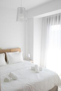a bedroom with a white bed with towels on it at Niovi Boutique Apartments in Afitos