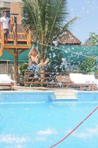 a group of people standing around a swimming pool at Hotel Port Louis in Mocoóca