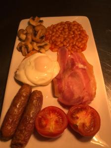 a plate of food with sausage beans and tomatoes at Duke Of Wellington in Matlock