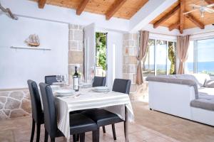 Un comedor blanco con una mesa y sillas. en Apartment Spila, en Ivan Dolac