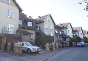 a car parked in front of a row of houses at Dom przy borowinie in Kołobrzeg