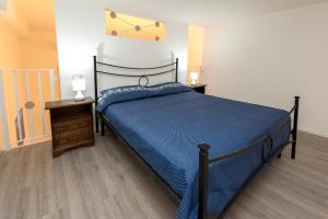 コンヴェルサーノにあるApulia Apartmentsのベッドルーム1室(青いベッド1台、ナイトスタンド2台付)