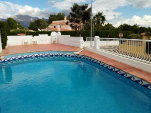 una piscina de agua azul frente a una casa en Ashanti Garden Luxury Short Term Rental Duplex Altea, en La Nucía