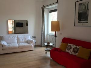 ローマにあるTiberHausのリビングルーム(白いソファ、赤い椅子付)