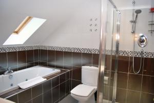 łazienka z wanną, toaletą i prysznicem w obiekcie The Old Schoolhouse Hotel w mieście Larkhall