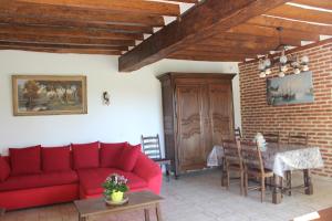 a living room with a red couch and a table at Gîte de Closeure in Billy