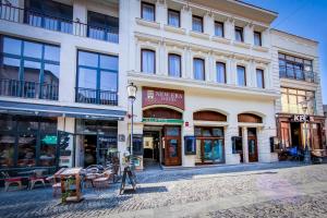 un edificio en una calle de la ciudad con tiendas en New Era Hotel Old Town - Covered pay parking within 10 minutes walk, en Bucarest