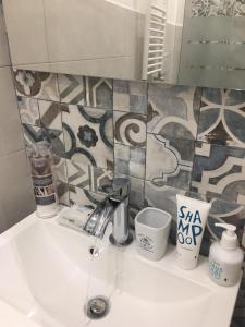un lavandino in bagno con tazze e specchio di Triglia a Genova