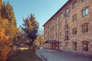 a large brick building with a bench in front of it at Apricot Aghveran Resort in Agveran