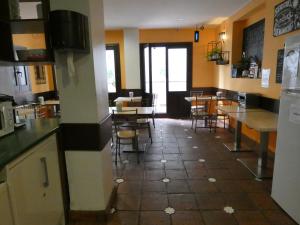 a kitchen and dining room with tables and chairs at Oasis Backpackers' Hostel Granada in Granada