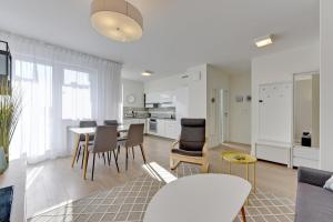 a living room and kitchen with a table and chairs at Aviator Modern 83 in Gdańsk