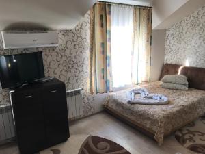 a small bedroom with a bed and a television at Fortuna in Cherche