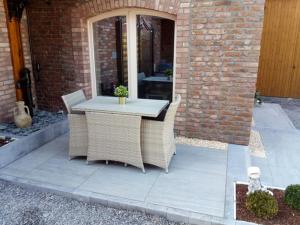 een tafel en stoelen op een patio bij L'Etable d'Evelyne in Bastenaken