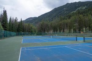 dois campos de ténis com montanhas ao fundo em Panorama Vacation Retreat at Horsethief Lodge em Panorama