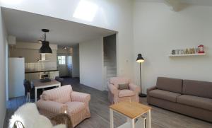 a living room with a couch and chairs and a kitchen at Vakantiehuizen 't Centrum in Oostkapelle