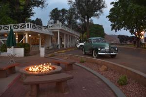 an old car parked in front of a building with a fire pit at Parry Lodge in Kanab