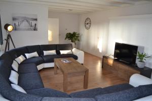 a living room with a couch and a tv at Walsbergshuisje in Deurne