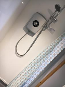 a hair dryer hanging from the ceiling of a bathroom at Greencraig Pods in Buckie +29 photos