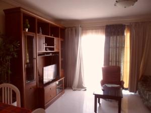 a living room with a television and a window at Arcoiris in Callao Salvaje