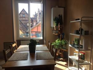 Un comedor con una mesa y una ventana. en Il Piano Nobile, en Colmar