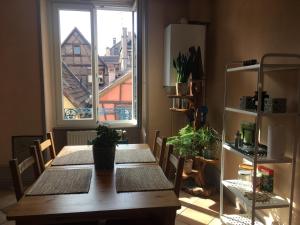 een eetkamer met een tafel en een raam bij Il Piano Nobile in Colmar