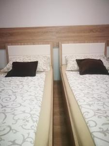 two beds sitting next to each other in a bedroom at Rooms Aračić in Slavonski Brod